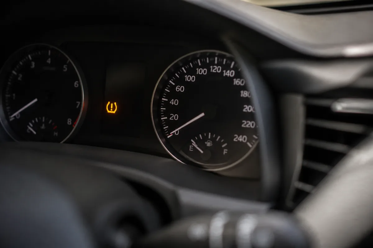 Tableau de bord de voiture éclairé avec le témoin orange de pression des pneus allumé