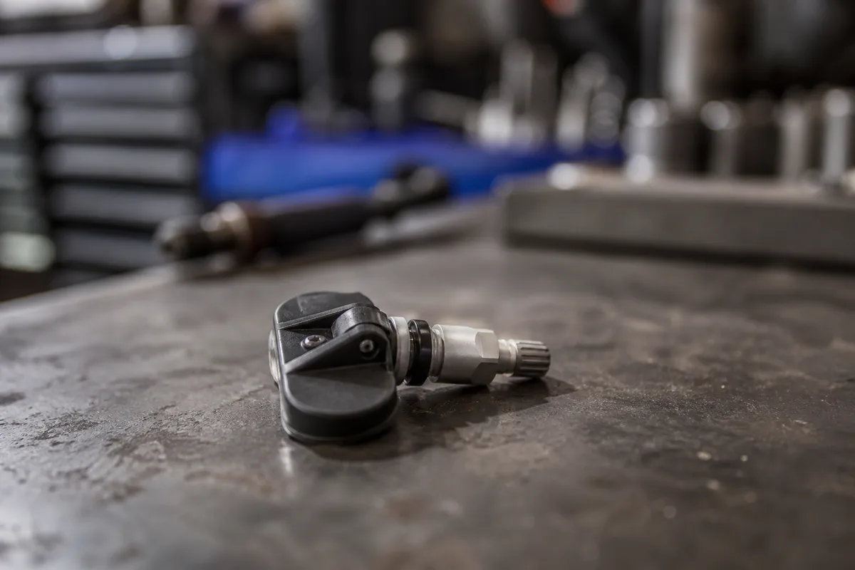 Capteur de pression solidaire d&rsquo;une valve, posé sur l&rsquo;établi d&rsquo;un atelier automobile